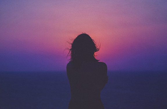 Purple sunset with women's silhouette in foreground