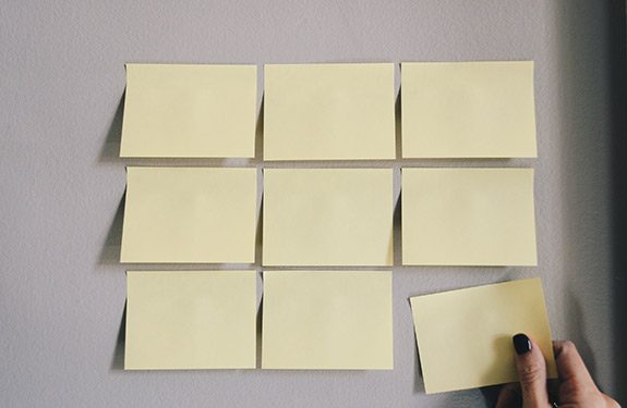 Student placing sticky notes on wall to help with job search