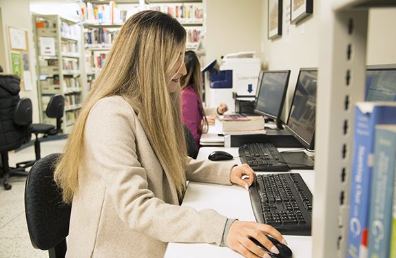 student using a computer inside the library