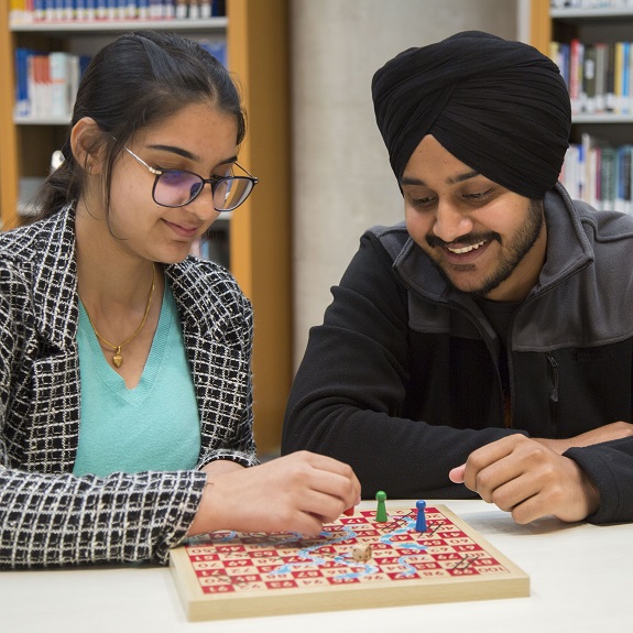 Image of two students playing a board game